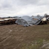 barn materials under tarps at Sonnenberg village awaiting rebuild